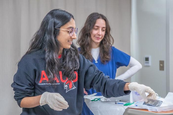 A student prepares to care for her patient during a simulation exercise.